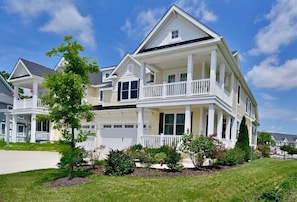 A two-story house with a porch, a garage, and a well-maintained lawn.
