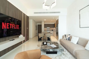 Apartamento Deluxe, balcón, vistas al mar | Zona de estar | Televisión de pantalla plana de 125 cm con canales digitales, Netflix