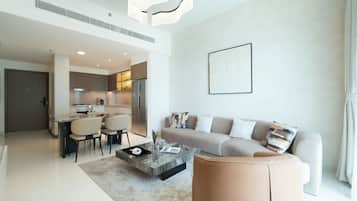 Departamento Deluxe, balcón, vista al mar | Área de sala de estar | Televisión de pantalla plana de 125 cm con canales digitales y Netflix