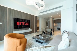 Departamento Deluxe, balcón, vista al mar | Área de sala de estar | Televisión de pantalla plana de 125 cm con canales digitales y Netflix