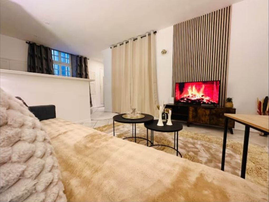 Ein gemütliches Wohnzimmer mit Kamin, einer Couch und einem Couchtisch.