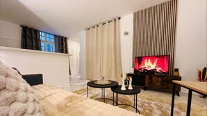 Una sala de estar acogedora con chimenea, un sofá y una mesa de centro.