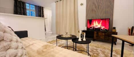 Un salon chaleureux avec une cheminée, un canapé et une table basse.