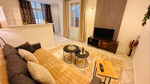 Una sala de estar moderna con sofá, mesa de centro y mueble para televisor.