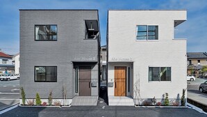 Two modern buildings labeled "Aile House II" and "Aile House I" with a narrow walkway between them.