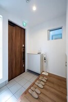 Un pasillo con una puerta de madera, un armario blanco y un ventanal.