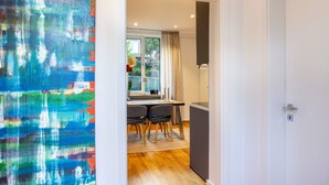 Una cocina moderna con comedor, piso de madera y vista a través de un ventanal.