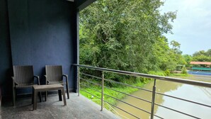Un balcón con dos sillas de mimbre y vista al río.