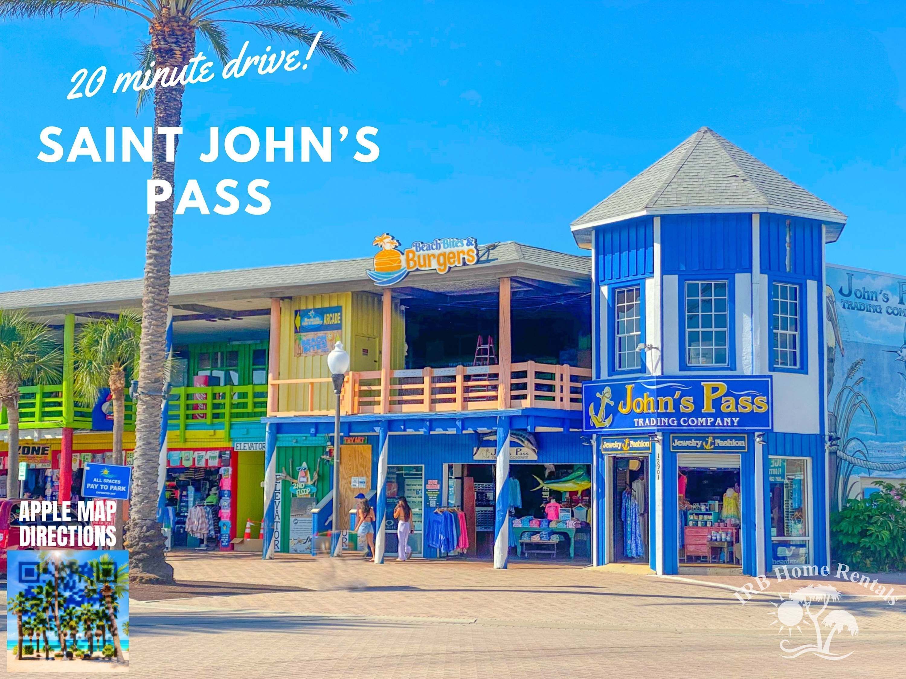 Un edificio colorido frente a la playa con tiendas y un letrero que dice 'John's Pass Trading Company'.