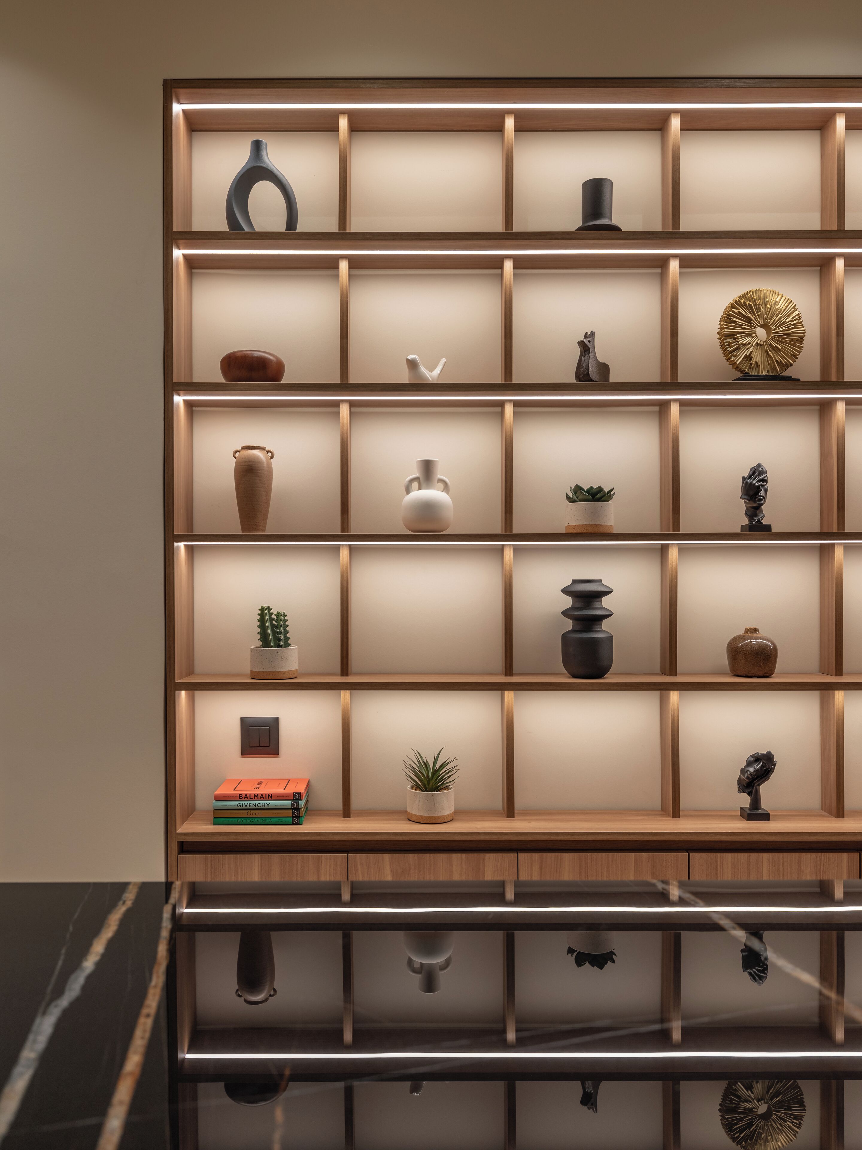 A modern bookshelf with multiple shelves, each containing various decorative items and books.