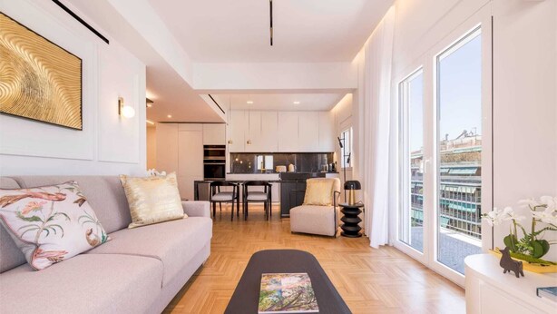 A modern living room with a sofa, a coffee table, and a view of the city through large windows. - Michalakopoulou Corner & Bright Apartment, Luxury (Athens)