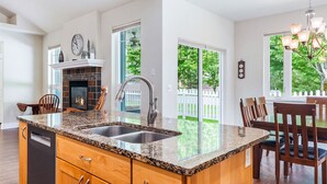 Una cocina moderna con encimeras de granito, lavavajillas integrado y chimenea.