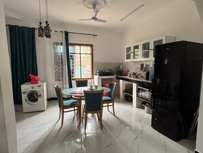 Een koelkast, een microgolfoven, kookgerei, borden en bestek