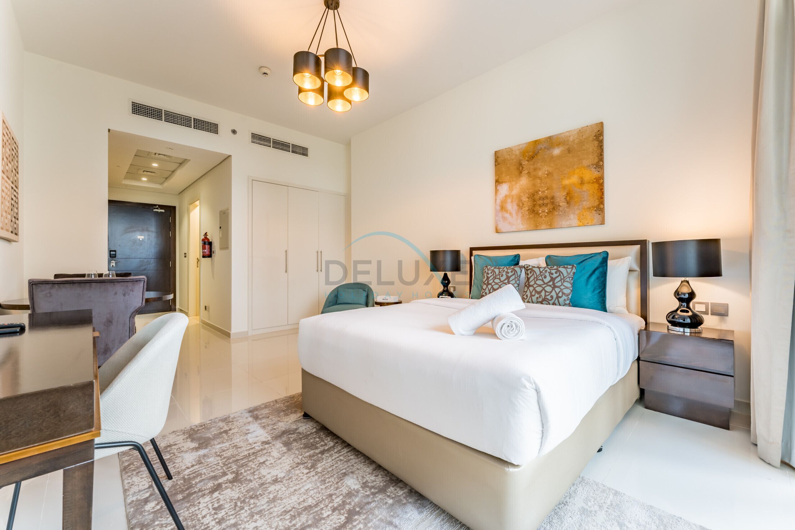 Een hotelkamer met een groot bed, nachtkastjes, een bureau en een stoel.