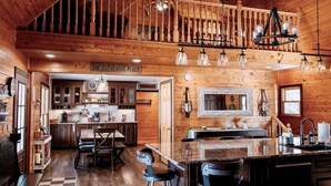 A rustic cabin interior with a kitchen, dining area, and a staircase. - Mirror Lake - Rare private lake! (Scales Mound)