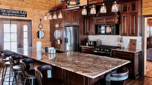 A spacious kitchen with a large island, wooden cabinets, and a sign reading "The Gathering Place". - Mirror Lake - Rare private lake! (Scales Mound)