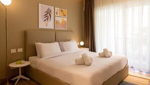 A hotel room with a large bed, a bedside table, and a wall with three framed artworks. - Kennah Milena | Stone Residence, New Cairo - Families Only (New Cairo)