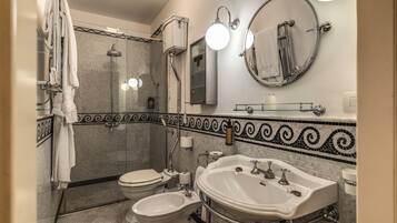 Un baño con ducha, inodoro, bidé y lavabo.