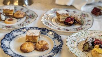 A table with various pastries and desserts on ornate plates.