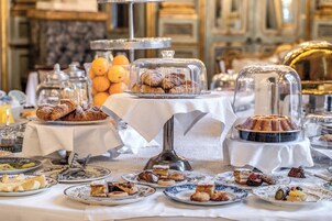 A breakfast buffet with various pastries and desserts displayed on a table.