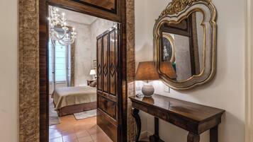 A bedroom with a bed, a dresser, a mirror, and a lamp.
