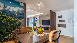 A dining area with a wooden table, leather chairs, and a fruit bowl.