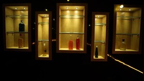 A series of display cases with bottles, likely in a hotel or similar establishment. - Bhraj Inn Hotel Udaipur (Udaipur)