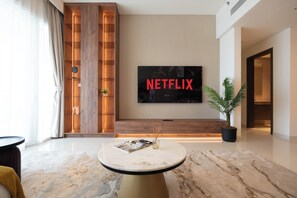 Apartamento Deluxe, balcón, vistas al mar | Zona de estar | Televisión de pantalla plana de 125 cm con canales digitales, Netflix