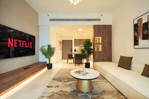 Apartamento Deluxe, balcón, vistas al mar | Zona de estar | Televisión de pantalla plana de 125 cm con canales digitales, Netflix