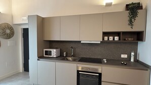 Una cocina moderna con electrodomésticos integrados, microondas, lavaplatos y estufa.