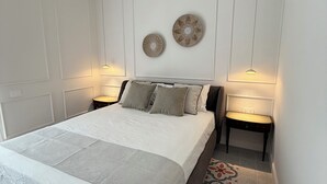 Un dormitorio con una cama grande, dos lámparas de pared y un adorno mural.