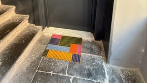 Una puerta negra con manija de metal y un pequeño candado.
