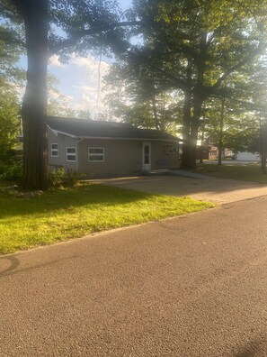 A single-story house with a front porch, a driveway, and a lawn.