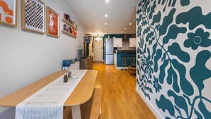 A modern kitchen with white cabinets, a wooden countertop, and a patterned wall. - Stylish Deptford Flat With Private Terrace (London)