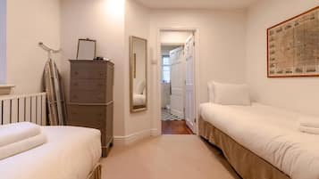 A bedroom with two beds, a dresser, a mirror, and a map on the wall.