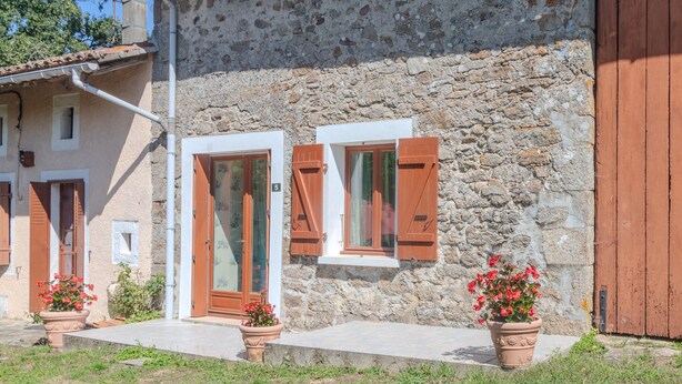 A stone building with wooden shutters, a tiled roof, and potted plants. - Holiday Home 'Des Tilleuls' with Private Garden (Saint-Mathieu)