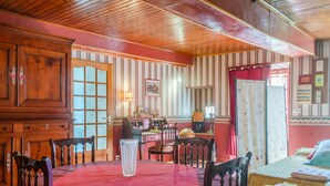 A room with a wooden ceiling, a dining table with chairs, a bed, and a window with curtains. - Holiday Home 'Des Tilleuls' with Private Garden (Saint-Mathieu)