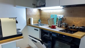 Una cucina compatta con lavastoviglie, forno e un piano di lavoro in legno.