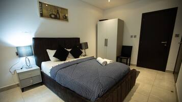 A bedroom with a bed, bedside tables, a wardrobe, and a door.
