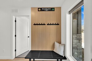A room with a wooden slat wall, a bench, and a sign that reads 'Best Day Ever snowbasin utah'.