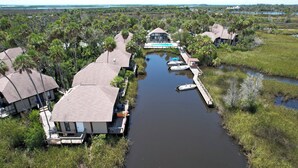 A riverside hotel with multiple buildings, a dock, and boats.
