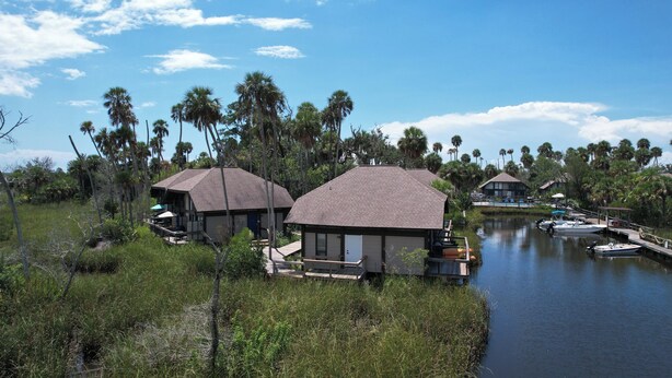 A waterfront property with two cabins, a dock, and a boat.