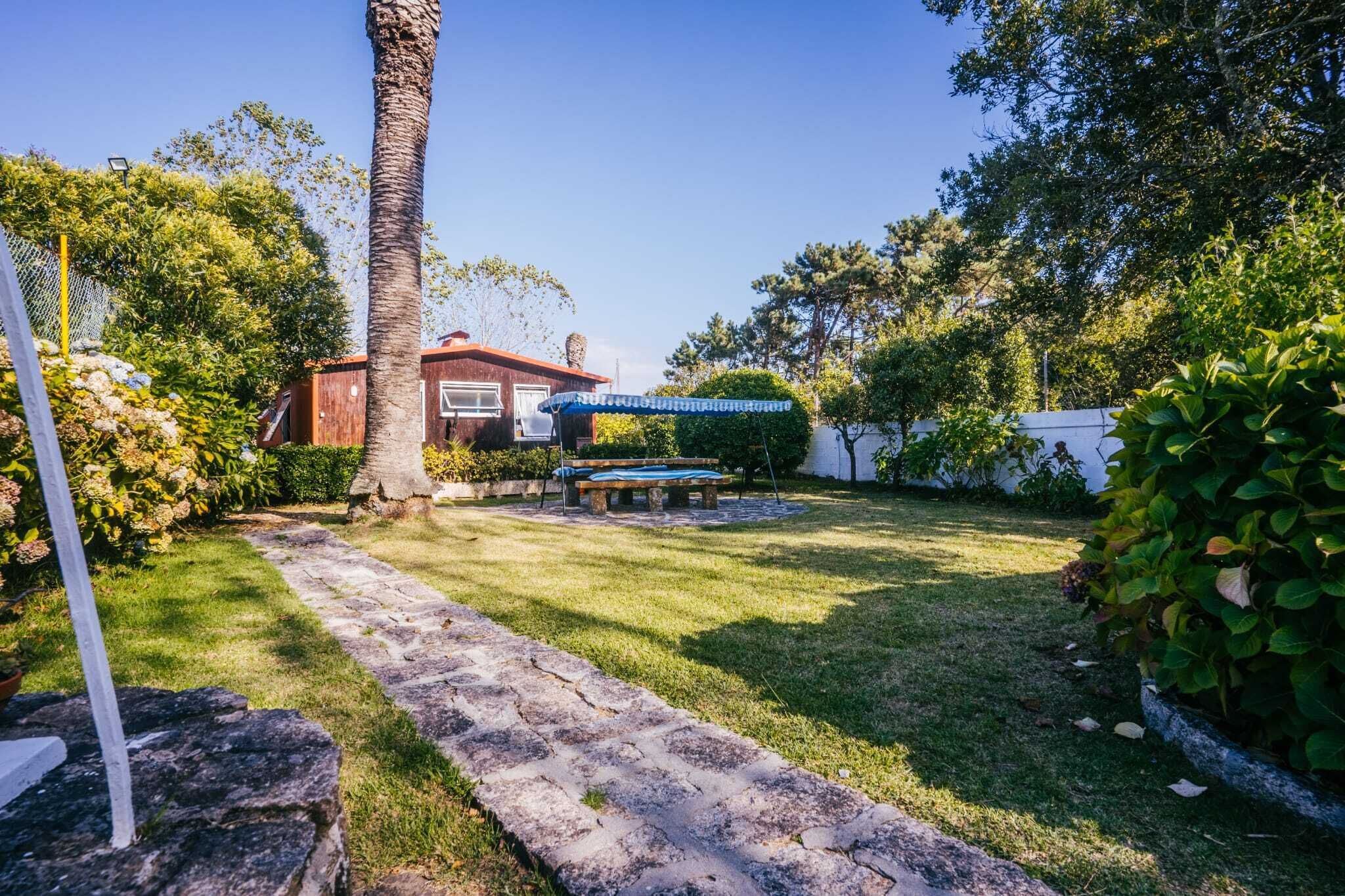 A well-maintained garden with a stone pathway, a bench, and a house in the background.