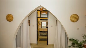 A narrow hallway with a sloped ceiling, a small sink area, and a potted plant. - 2BR Apt, 6-Min Walk to Diani Beach, Kids Playground, Near Ukunda Airport. (Diani Beach)