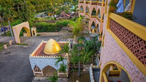A courtyard with a yellow dome structure, a white building with arches, and a blue-roofed building in the background. - 2BR Apt, 6-Min Walk to Diani Beach, Kids Playground, Near Ukunda Airport. (Diani Beach)