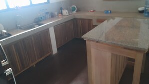 Een keuken met houten kastjes, een aanrecht en een spoelbak.