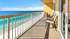 Un balcon avec vue sur l’océan, aménagé avec du mobilier d’extérieur et doté d’une rambarde en verre.