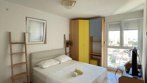 A bedroom with a bed, a wooden ladder, a wardrobe, and a desk with a computer. - Charming 1-bedroom apartment in delightful Split with AC (Split)