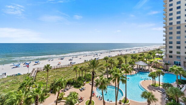 Un resort con piscina, playa y vista al océano.