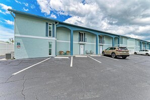 Un motel avec un parking et un VUS beige garé devant.